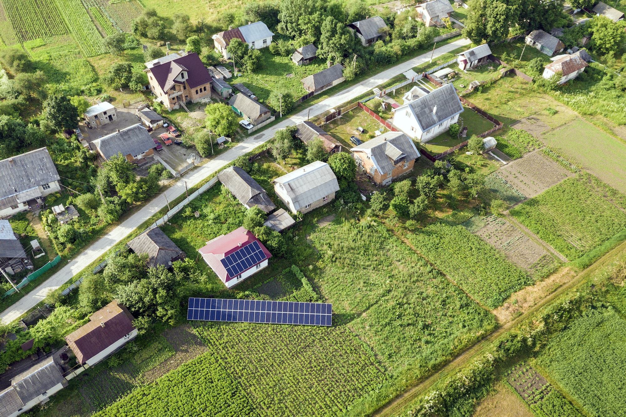 Aerial view of a house with blue solar panels for clean energy